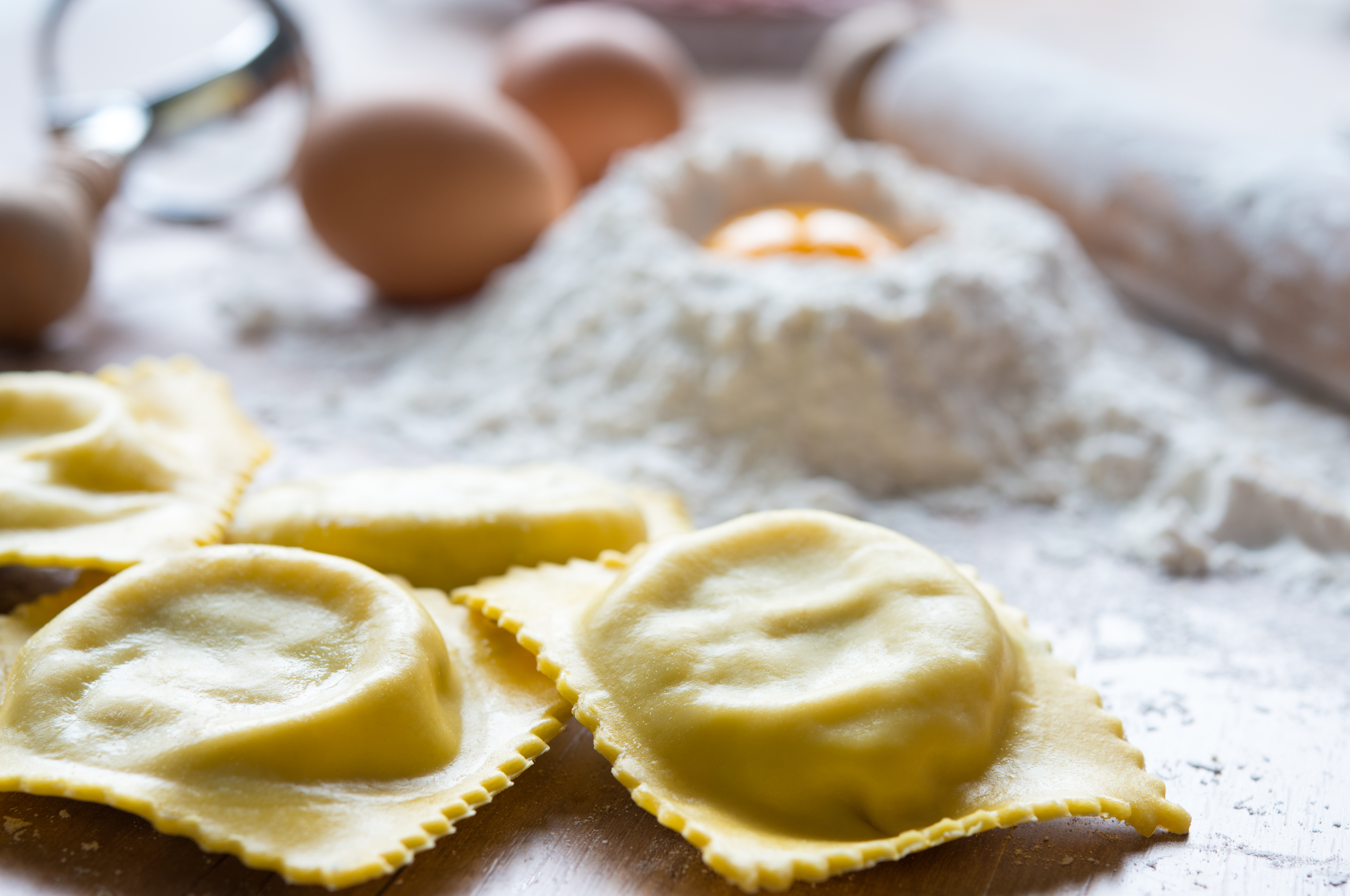 Fresh homemade ravioli with flour and eggs ready for cooking.