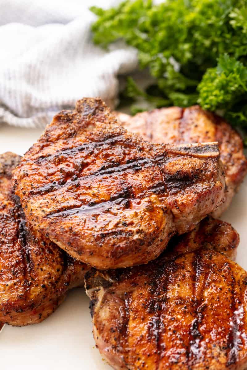 Juicy grilled pork chops with char marks and seasoning.