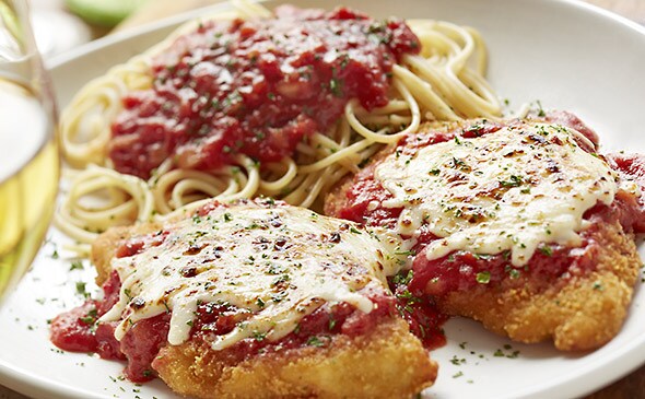 Plate with chicken parmesan and spaghetti in tomato sauce.