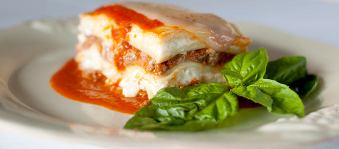 A delicious slice of lasagna with tomato sauce and fresh basil.