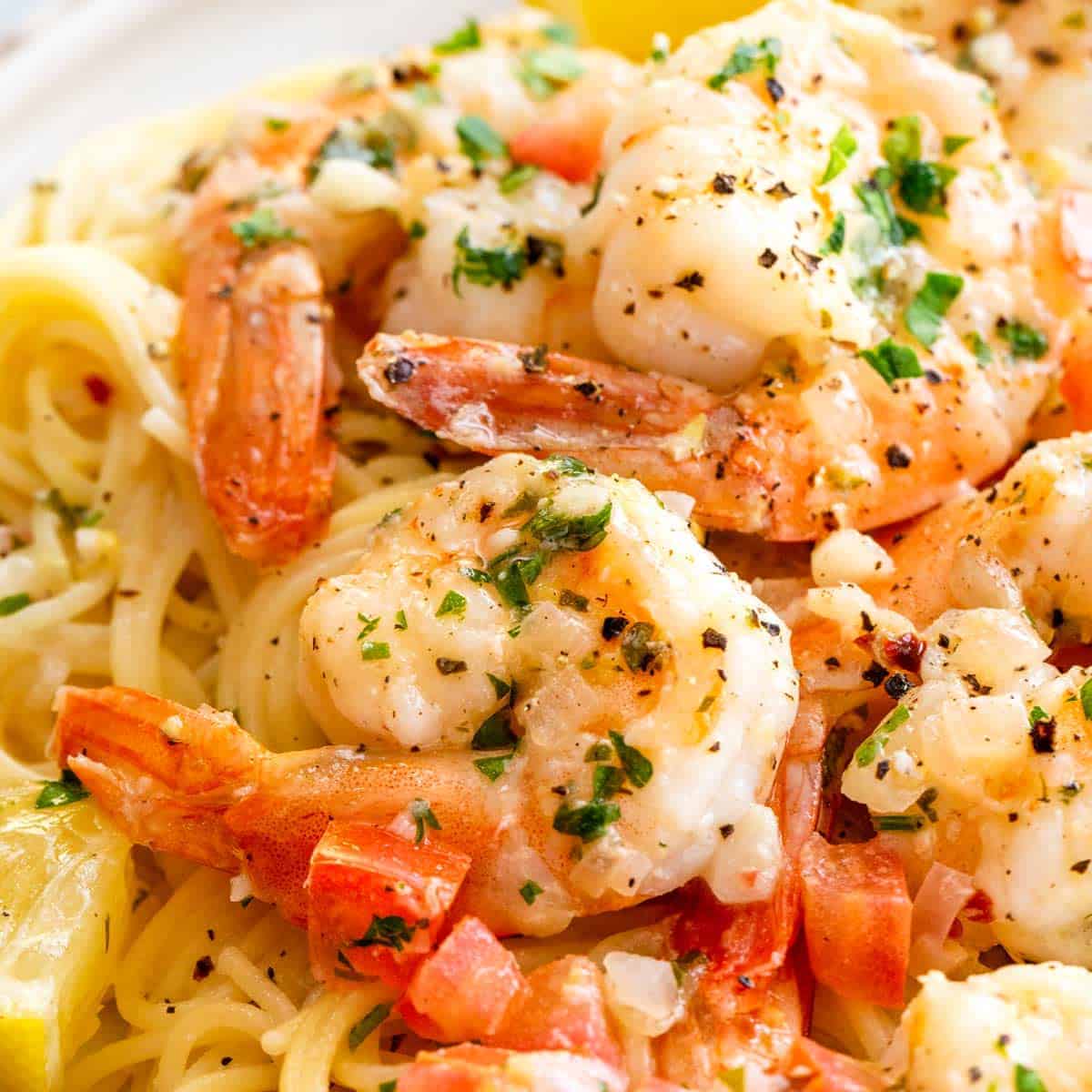 Close-up of shrimp pasta garnished with herbs and spices.