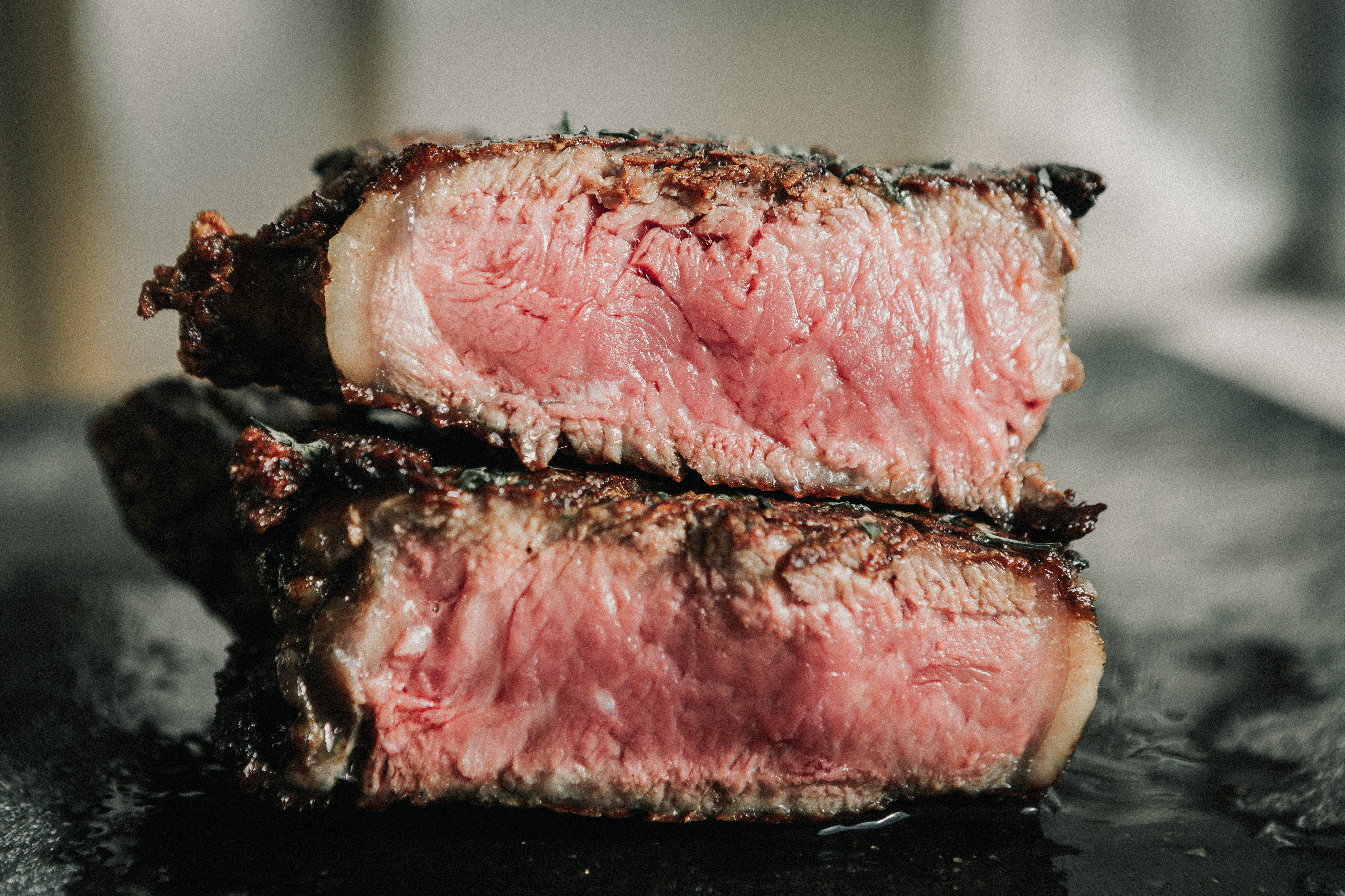 Close-up of a juicy medium-rare steak cut in half.